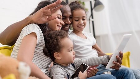 Family planning their Walt Disney World vacation on a phone and tablet with the My Disney Experience app